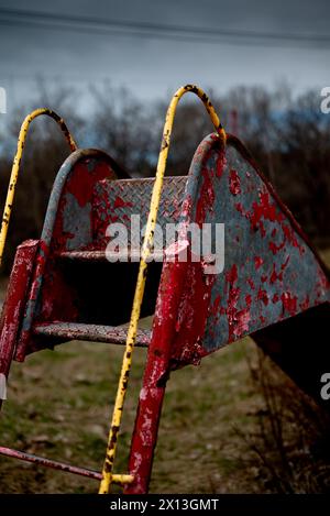 Vecchio scivolo arrugginito in un parco giochi abbandonato Foto Stock