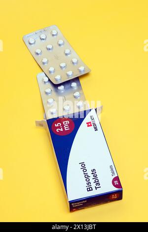 Scatola da 28 2,5 mg compresse di bisoprololo di Medreich, compresse per ipertensione, ipertensione su sfondo giallo Foto Stock