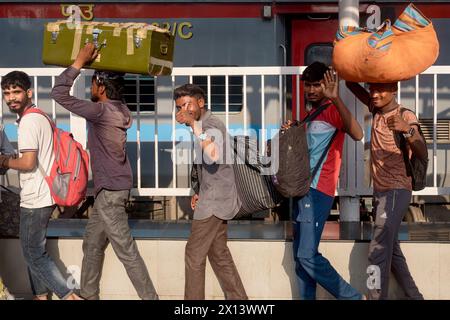 Lavoratori migranti dall'Uttar Pradesh nell'India settentrionale in coda per salire a bordo di un treno per il loro stato d'origine; al Chhatrapati Shivaji Maharaj Terminus, Mumbai, India Foto Stock