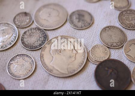 Una selezione di vecchie monete britanniche su un tavolo al Weald & Downland Living Museum di Singleton, Chichester, West Sussex, Regno Unito. Foto Stock