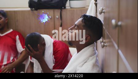 Immagine di cellule di virus sopra diversi giocatori di calcio maschile in spogliatoio Foto Stock