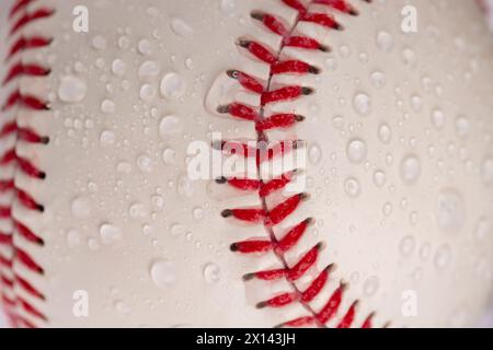 palla da baseball bianca legata con filo rosso, una vera palla da baseball rotonda in primo piano Foto Stock