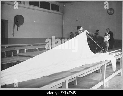 I PARACADUTISTI BRITANNICI: IL SERVIZIO PORTA A SILK - ogni saltatore aiuta a piegare il suo "scivolo di seta" nel suo container Royal Air Force Foto Stock