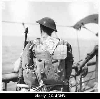 INVASIONE DELLA SICILIA - soldato "l'invasore completo" a bordo pronto a sbarcare. Il libro nascosto nel retro del suo branco è The Soldiers Guide to Sicily, un opuscolo rilasciato a tutti gli uomini della forza d'invasione British Army Foto Stock