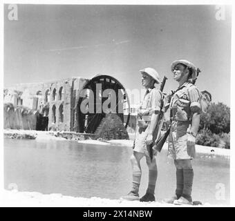 Le truppe britanniche sono in guardia vicino a una grande ruota ad acqua, osservando il paesaggio durante le operazioni in Siria. Foto Stock