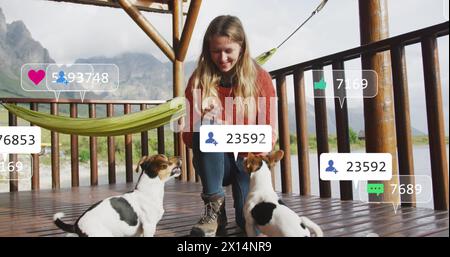 Immagine del testo dei social media e delle icone sulla donna caucasica con i cani sulla terrazza Foto Stock