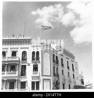 TUNISI - SCENE DOPO LA CADUTA DELLA CITTÀ - l'Union Jack vola sopra uno dei principali edifici dell'esercito britannico Foto Stock