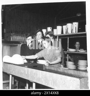 FORMAZIONE PER RAGAZZE NEL FINE SETTIMANA DI ADDESTRAMENTO UFFICIALI DEL CORPO - gli ufficiali in visita guardano gli ausiliari A.T.S. al lavoro nel Training Centre cookhouse British Army Foto Stock