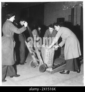 ATS AL LAVORO PRESSO ORDNANCE DEPOT - le donne del punto vendita ATS caricano piccole balle di abbigliamento su un autocarro ferroviario British Army Foto Stock