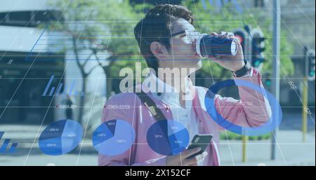 Immagine di grafici, numeri, uomo asiatico che attraversa la strada mentre beve caffè e usa il cellulare Foto Stock