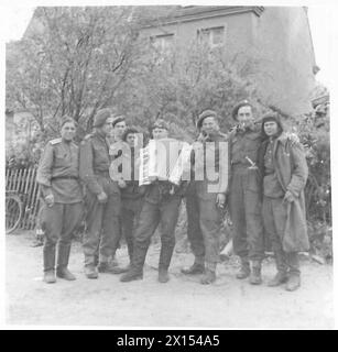 I soldati russi e britannici tengono una canzone insieme a una fisarmonica durante il collegamento delle forze alleate in Europa. Foto Stock