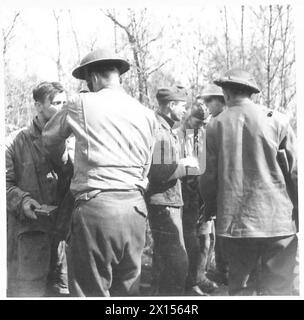 ITALIA: QUINTO CAPO DI PONTE ARMYANZIO - prigionieri di un reggimento di paracadutisti tedesco in cerca di documenti da parte di uomini della sezione "i" del Royal Fusiliers British Army Foto Stock