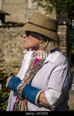 Cognac, Francia -- 14 aprile 2024. Una foto verticale di una donna americana turistica a Cognac, in Francia, con il braccio rotto sospeso in una calotta blu. Foto Stock