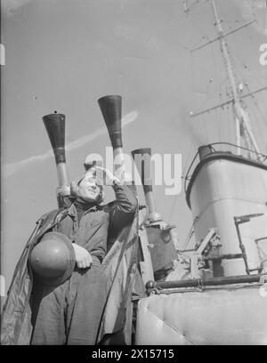 A BORDO DEL DESTROYER HMS KELVIN. 1941. - Un membro di un equipaggio di pistole che indossa un casco antiesplosione che riceve ordini dal ponte Foto Stock