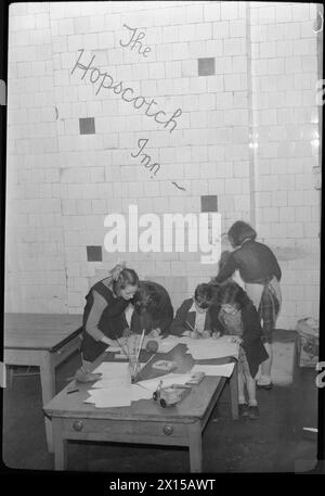 HOPSCOTCH INN: OPERA DEL SAVE THE CHILDREN FUND IN TEMPO DI GUERRA LONDRA, INGHILTERRA, Regno Unito, 1944 - i bambini si divertono all'Hopscotch Inn, un club gestito da Save the Children su Eversholt Street, Londra. Al tavolo Peggy Barker, Jean McGann, Dolly Phillips e Bobby Love disegnano, mentre un altro bambino stokes la stufa dietro di loro. Il club offre un ambiente caldo e sicuro in cui i bambini possono giocare e fare amicizia. Le parole "Hopscotch Inn" sono state dipinte sulle pareti e sono chiaramente visibili dietro i bambini Foto Stock