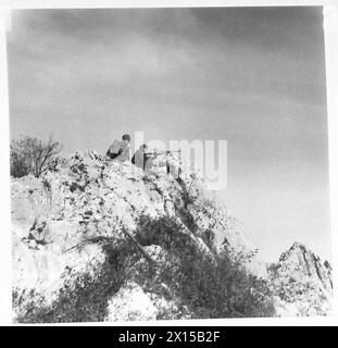 I combattenti partigiani in Jugoslavia si posizionano su un terreno roccioso per osservare e affrontare le forze nemiche in avvicinamento. Foto Stock