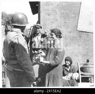 Alla testa di ponte di Anzio, il personale della Quinta Armata distribuisce tavolette di mepacrina ai civili rimasti, con S/Sgt. Ciancio istruisce una famiglia italiana sul loro uso per prevenire la malaria. Foto Stock