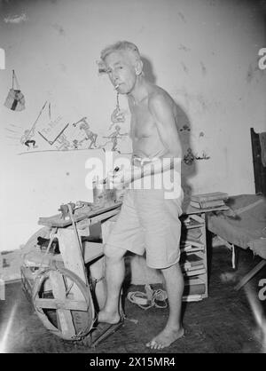 AL CAMPO DI INTERNAMENTO STANLEY, HONG KONG. AGOSTO E SETTEMBRE 1945. - L'abitante più anziano del campo, Mr A Raven, 70 anni, un architetto dello Yorkshire, dimostra che la sua casa ha fatto il tornio che ha cionstrusso con pezzi e pezzi scrostati dalle guardie giapponesi e frullati da rottami nel campo. Il tornio è stato appositamente realizzato per trasformare le fedi nuziali da 10 centesimi di pezzi di Hong Kong per le donne sposate che sono state costrette a vendere le loro monete d'oro per i servizi igienici essenziali e il cibo. Altri articoli forniti dal tornio del signor Raven erano bottoni per i vestiti fatti in casa che gli internati erano fatti con pezzi di r Foto Stock