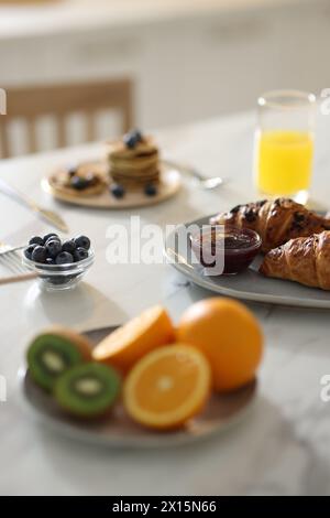 Colazione gustosa. Croissant freschi con marmellata su tavolo in marmo bianco, attenzione selettiva Foto Stock