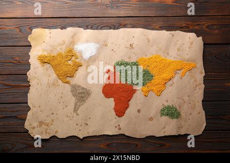 Mappa del mondo di diverse spezie su un tavolo di legno, vista dall'alto Foto Stock