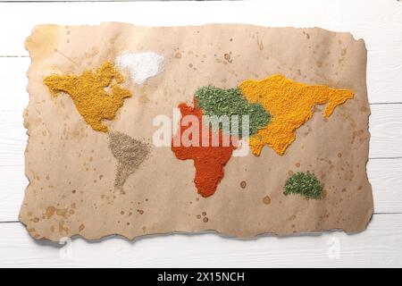 Mappa del mondo di diverse spezie su un tavolo di legno bianco, vista dall'alto Foto Stock
