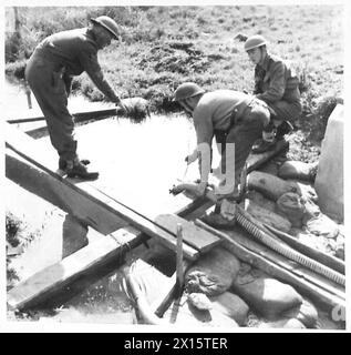 Alla testa di ponte di Anzio, il personale della Quinta Armata colloca una pompa d'acqua in un torrente, filtrando l'acqua; Lieut. Hughes, SPR. MacFarlane e il sergente Beswick conducono l'operazione. Foto Stock