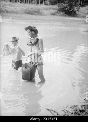 MOMENTI TROPICALI. 7 E 8 AGOSTO 1945, HMS RAJALYIA, ROYAL NAVAL AIR STATION PUTTALAM, CEYLON. ATTIVITÀ E PERSONALITÀ ALLA ROYAL NAVAL AIR STATION. - Lavando i loro "piccoli" in una piscina nella giungla a Ceylon ci sono Marine G Hall di Pendelbury, Manchester (a sinistra) e Marine W Will di Rosyth Foto Stock