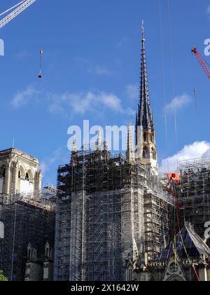 Parigi, Francia, Europa. 15 aprile 2024: Nel 5° anniversario dell'incendio che ha distrutto gran parte della Cattedrale di Notre Dame, i lavoratori sono impegnati a rimuovere alcune impalcature dalla guglia appena installata e a continuare a restaurare l'edificio con l'avvicinarsi dell'apertura al pubblico nel dicembre 2024. Foto Stock