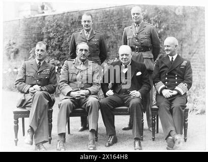 IL PRIMO MINISTRO INTRATTIENE I CAPI DI STATO MAGGIORE AL PRANZO AL N.10 DI DOWNING STREET - seduti - da sinistra a destra - Sir Charles Portal, Sir Alan Brooke RT. Winston Churchill e Andrew Cunningham. In piedi - da sinistra a destra - il maggiore generale L.C.Hollis [Segretario del Comitato dei capi del personale] e il generale Sir Hastings Ismay, [Capo di Stato maggiore del Ministro della difesa] British Army Foto Stock