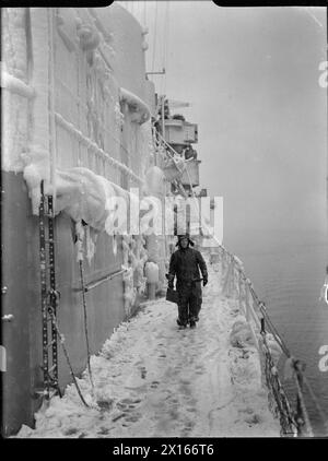 Un membro dell'equipaggio si trova sul ponte innevato della HMS Scylla mentre era in pattuglia nel Nord Atlantico durante la seconda guerra mondiale Foto Stock