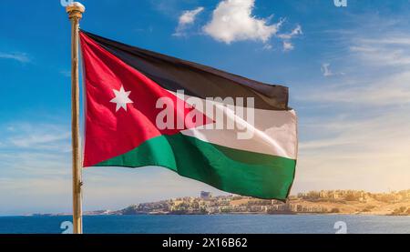 Die Fahne von Jordanien flattert im Wind, isoliert gegen blauer Himmel Foto Stock