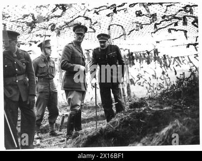 LA VISITA DEL DUCA DI GLOUCESTER NELL'EAST ANGLIA - H.R.H. vista sotto una rete mimetica dell'esercito britannico Foto Stock