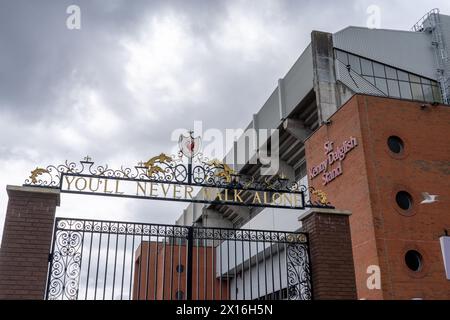 Il famoso slogan non potrai mai camminare da solo sopra un cancello dello stadio Liverpool FC di Anfield, Liverpool Foto Stock