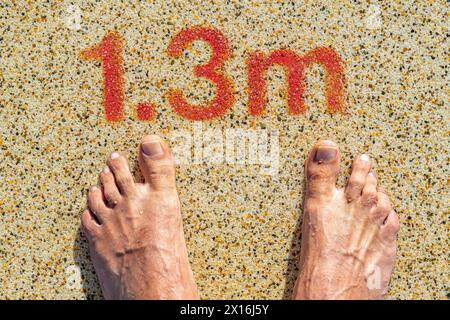 due piedi all'ingresso della piscina con un'indicazione di profondità di 1,3 metri Foto Stock