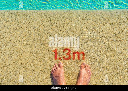 due piedi all'ingresso della piscina con un'indicazione di profondità di 1,3 metri Foto Stock