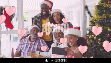 Immagine di icone del cuore sulla famiglia afroamericana con cappelli di babbo natale Foto Stock