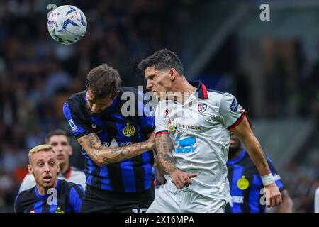 Milano, Italia. 14 aprile 2024. Francesco Acerbi del FC Internazionale (L) e Alessandro di Pardo del Cagliari calcio (R) competono per il pallone durante la partita di calcio di serie A 2023/24 tra FC Internazionale e Cagliari calcio allo stadio Giuseppe Meazza. Punteggio finale; Inter 2:2 Cagliari. Credito: SOPA Images Limited/Alamy Live News Foto Stock