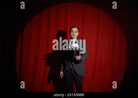 Elegante misterioso illusionista che mostra trucchi con coniglio Foto Stock