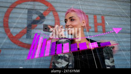 Immagine di una freccia sui grafici che cadono sulla donna birazziale che parla sull'altoparlante del cellulare Foto Stock