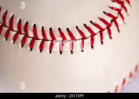 palla da baseball bianca legata con filo rosso, una vera palla da baseball rotonda in primo piano Foto Stock