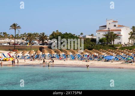 I turisti apprezzano l'acqua di mare nella località di Cala en Bosc, sull'isola spagnola di Minorca. Foto Stock