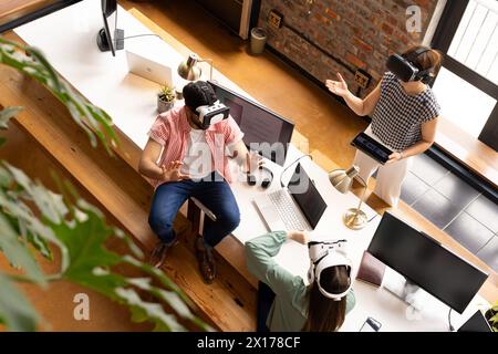 Un team diversificato di professionisti che indossano occhiali VR in ufficio Foto Stock