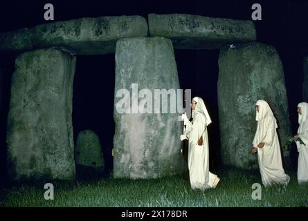 I druidi si riuniscono a Stonehenge, un antico monumento preistorico pagano per il solstizio d'estate. Si riuniscono la sera prima. Il culto pagano e i riti religiosi vengono eseguiti per tutta la notte fino all'alba e all'alba sopra le pietre del tallone. Salisbury Plain. Wiltshire, Inghilterra. Intorno agli anni '1975 1970 del Regno Unito HOMER SYKES Foto Stock