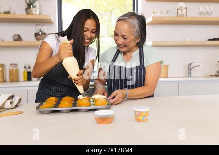 Nonna asiatica e nipote adolescente birazziale stanno cucinando insieme a casa Foto Stock