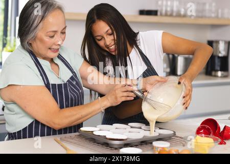 Nonna asiatica e nipote adolescente birazziale stanno cucinando insieme a casa Foto Stock