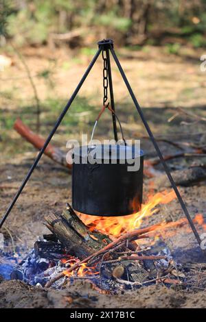 bollitore per turisti affumicato sul fuoco nella foresta Foto Stock