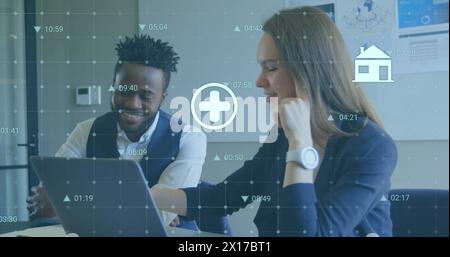 Immagine di più icone digitali su diversi uomini d'affari e donne d'affari che discutono in ufficio Foto Stock