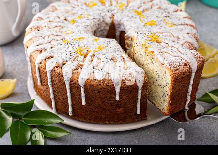 Torta con semi di papavero al limone, torta intera con una fetta tolata Foto Stock