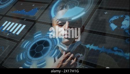 Immagine della scansione di ambito ed elaborazione dei dati sopra l'uomo birazziale che indossa la maschera facciale Foto Stock