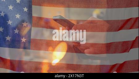 Immagine della bandiera americana che sventola sull'uomo usando il telefono sullo sfondo Foto Stock